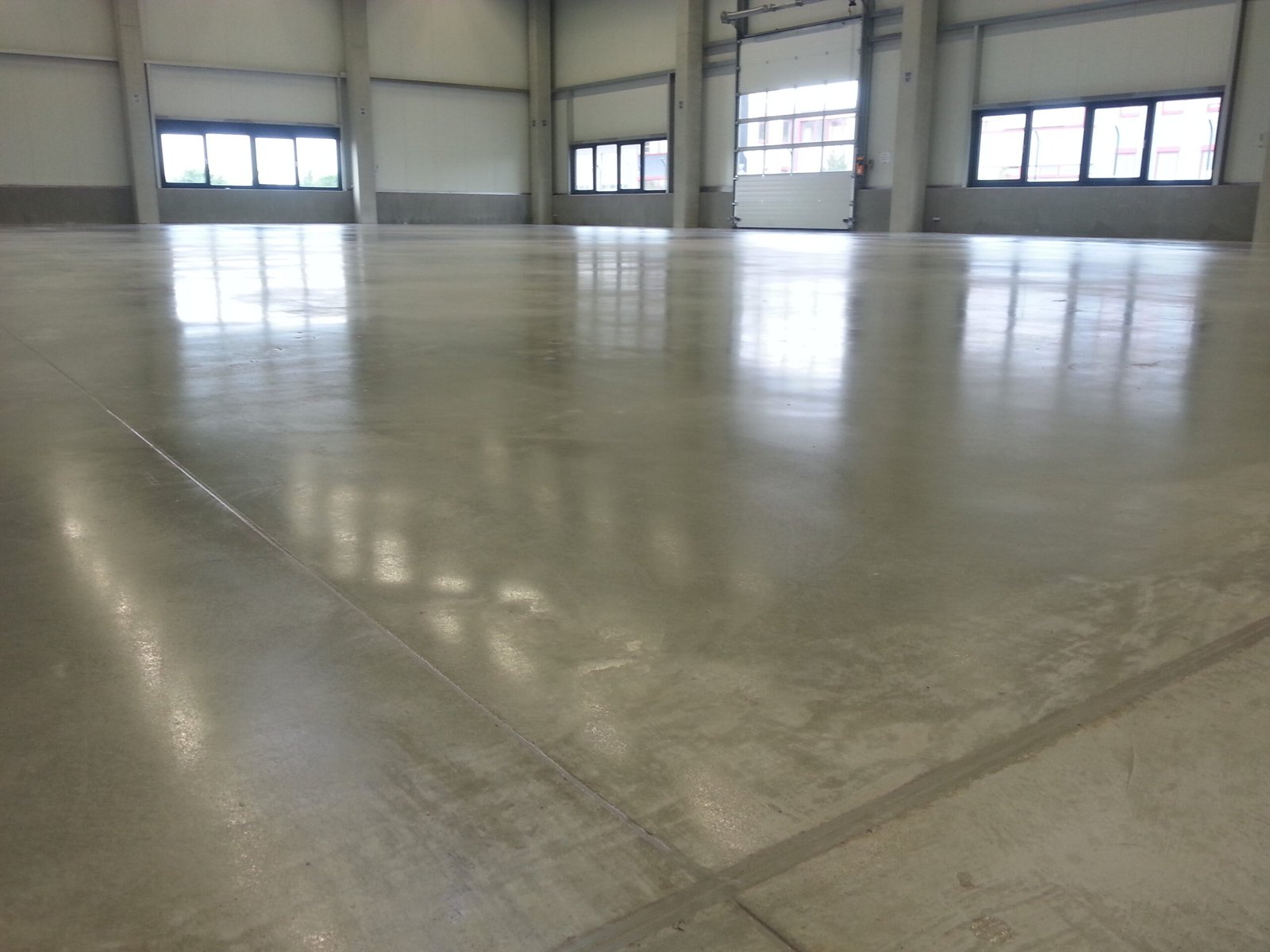 Hartstoffvergütung und maschinelles Glätten eines Industriebodens für maximale Widerstandsfähigkeit